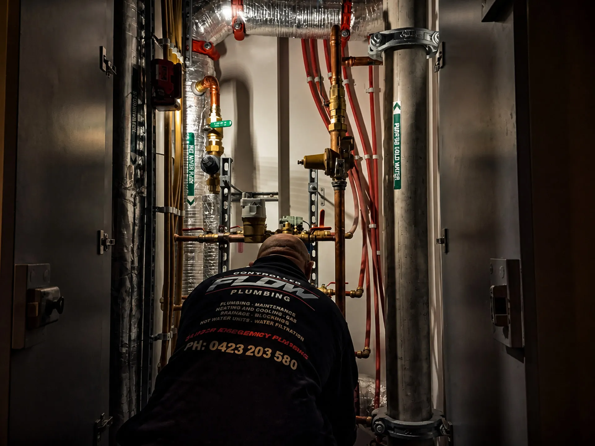 Controlled Flow Plumbing technician servicing hydraulic pipework in a commercial plant room