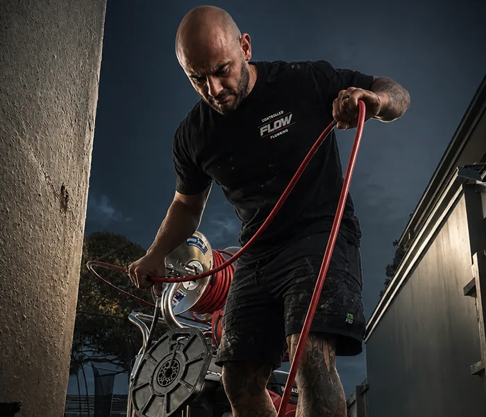 Controlled Flow Plumbing technician using a hose reel leak detection unit to investigate a water loss issue